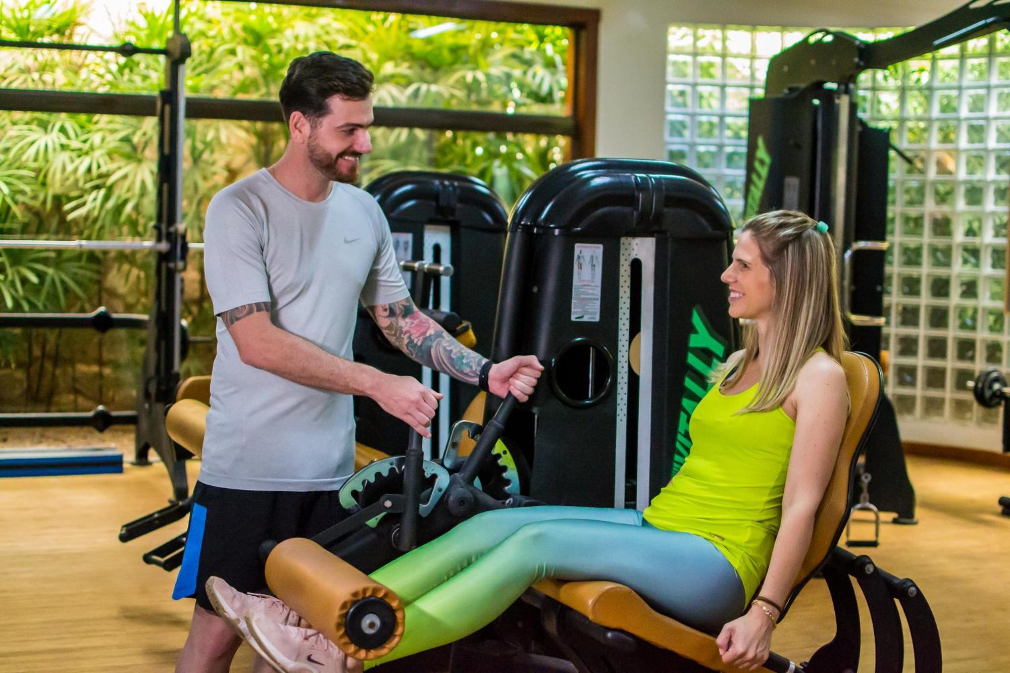 Blue Tree Thermas De Lins Resort Dış mekan fotoğraf Personal trainer assisting a woman on a leg press machine